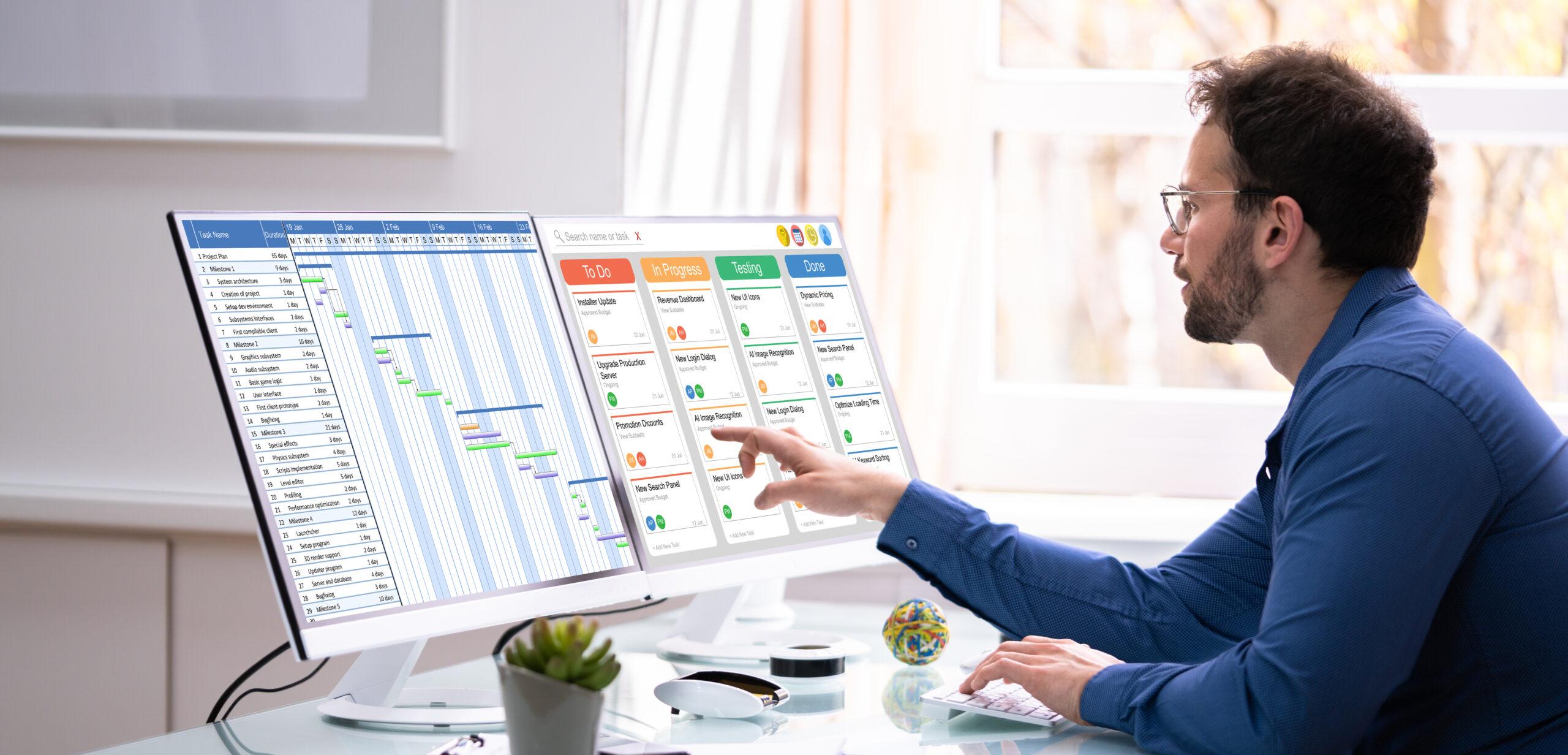 Male marketing project manager looking at gantt chart and kanban board