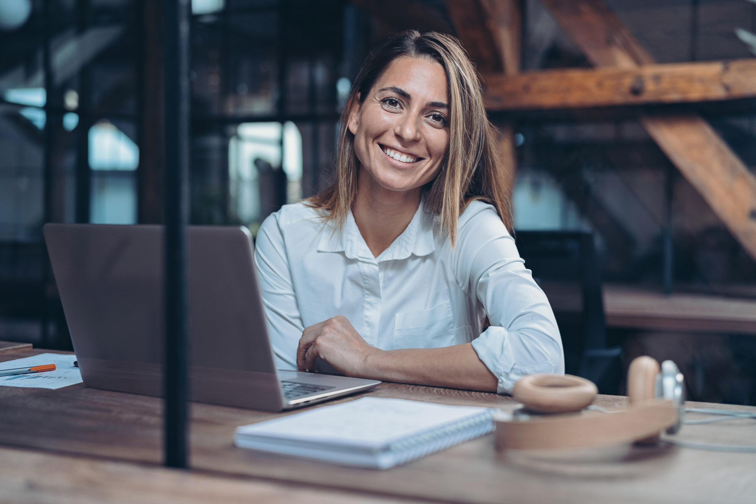 female marketing manager sat at her desk facing the camera