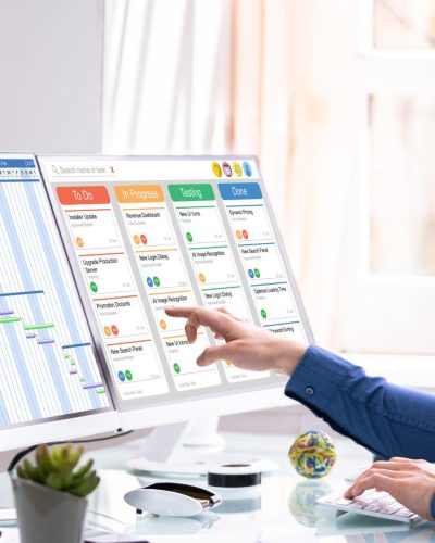 Male marketing project manager looking at gantt chart and kanban board